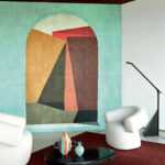 Modern interieur met Elitis-behang Medina VP 946 01 in geometrisch design, omringd door designmeubilair en decoratieve accessoires.