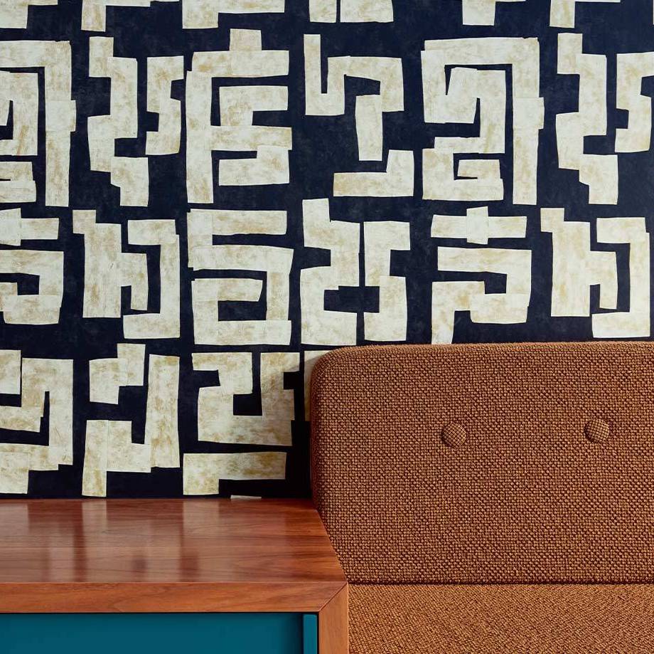 Modern interieur met Elitis-behang uit de Voile de Papier-collectie, featuring abstract geometrisch patroon op een donkere achtergrond.