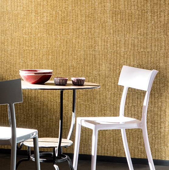 Tafel met moderne stoelen en aardewerk voor een Elitis Natural Mood behang in warme, geweven textuur.