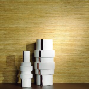 Twee moderne witte vazen staan voor Elitis-behang Talamone Seta met een goudkleurige textuur.