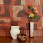 Stillleven met Elitis-behang Tutto TP 333 uit de Voile de Papier-collectie, met een witte vaas, smalle bloemenvaas en decoratieve schaal.
