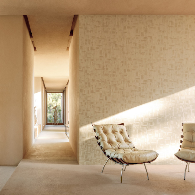 Luxe interieur met Elitis-behang Bois Sculpté Ramille VP 938 20 en moderne designfauteuils in een warme, minimalistische ruimte.
