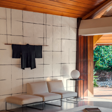 Luxe interieur met Elitis Hanji Nishino behang, minimalistische zitmeubels en een zwarte kimono als wanddecoratie.