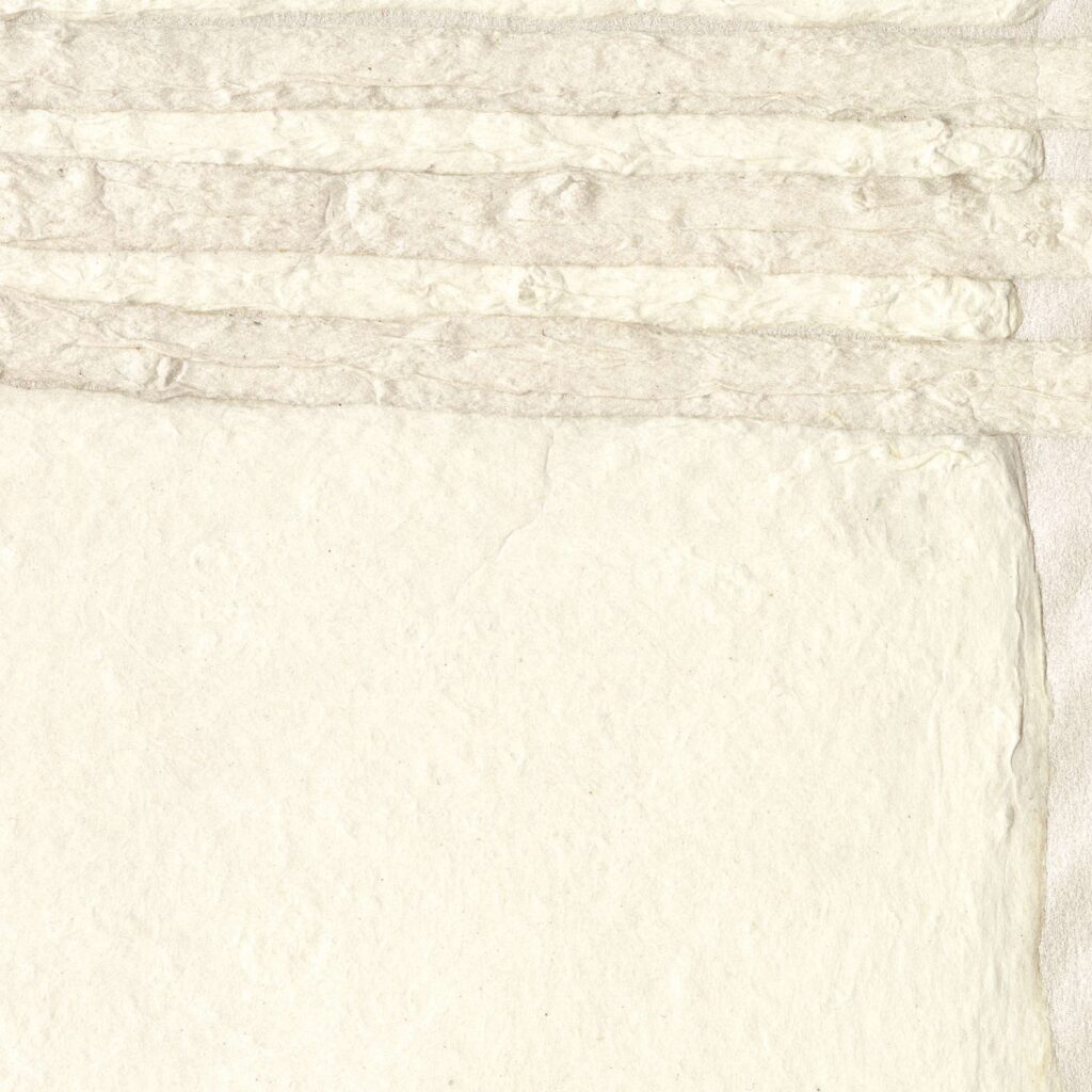Detailopname van Elitis behang Hanji Noto RM 1058 01 met een handgeschept papiertextuur in zachte crèmetinten.
