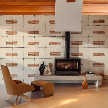 Moderne woonkamer met Elitis Hanji Noto RM 1058 02 behang, een strakke haard en designmeubels in warme aardetonen.