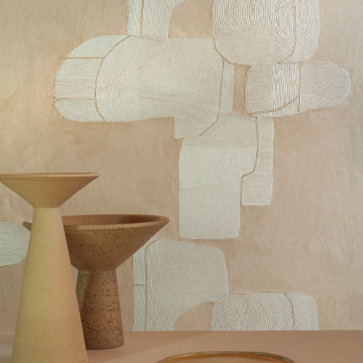 Decoratieve Elitis Hanji Takara RM 1062 04 muur met abstract behang in beige tinten en aardewerken schalen op de voorgrond.