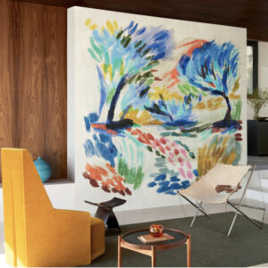 Moderne zithoek met kleurrijk Elitis-behang "La Caravane au Pied du Ventoux" als kunstzinnige eyecatcher op de muur.
