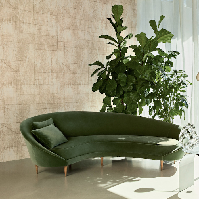Groene fluwelen designbank voor Elitis-behang La Caravane Chogak VP 943 in crèmekleurige sfeer.