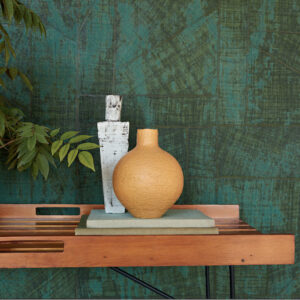 Sfeervolle interieursetting met Elitis-behang La Caravane Chogak VP 943 in groen, houten tafel en decoratieve vazen.