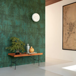 Moderne interieurhoek met Elitis behang La Caravane Chogak VP 943 in groen, houten bankje en decoratieve objecten.