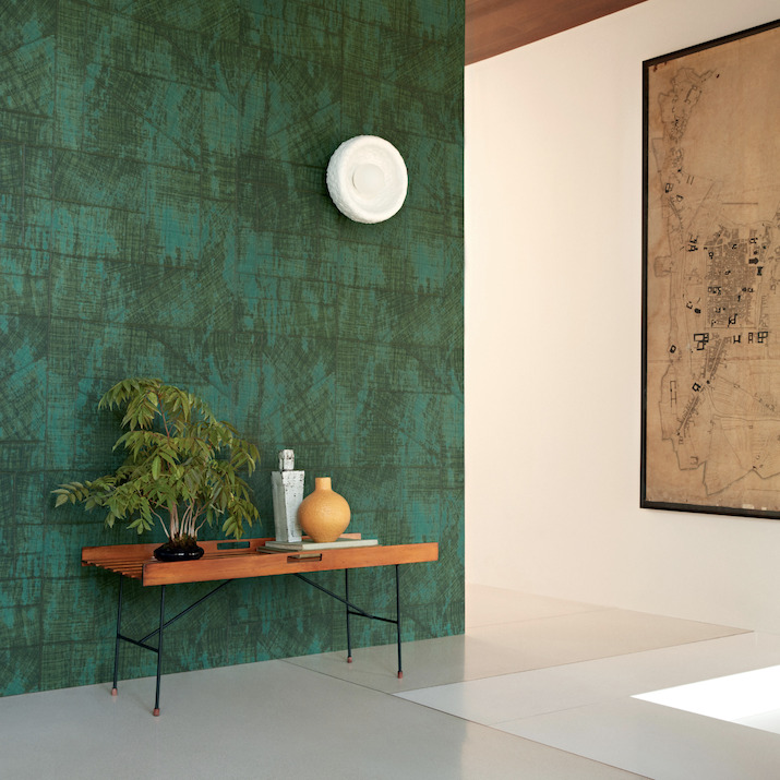 Moderne interieurhoek met Elitis behang La Caravane Chogak VP 943 in groen, houten bankje en decoratieve objecten.