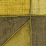 Detail van Elitis-behang La Caravane Kungbo VP 944 08 met geometrische patronen in gele en aardetinten met een textielstructuur.