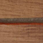 Detail van Elitis behang La Caravane Moshi Moshi VP 942 05 met een geweven textuur in aardetinten en decoratieve franjes.