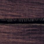 Detail van Elitis-behang La Caravane Moshi Moshi VP 942 11 met een geweven textuur in paarse en bruine tinten en een decoratieve franje.