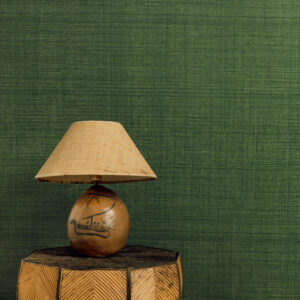 Tafel met decoratieve lamp voor groen Elitis behang uit de Matières Végétales Abaca collectie.