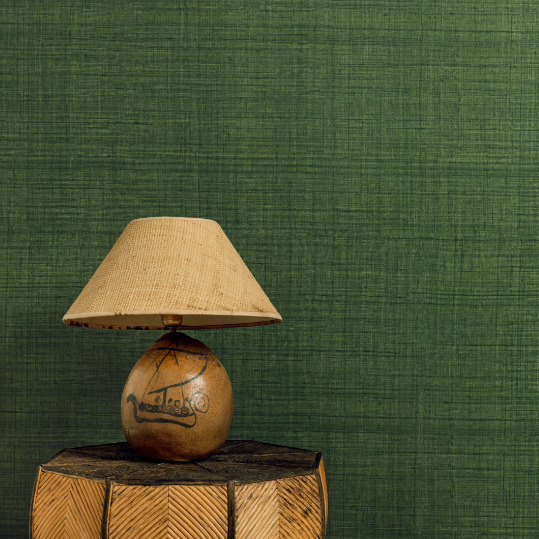 Tafel met decoratieve lamp voor groen Elitis behang uit de Matières Végétales Abaca collectie.