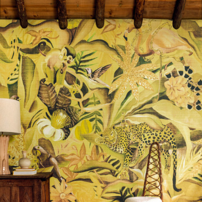 Sfeerbeeld van een interieur met het Elitis-behang 'Matières Végétales Costalegre VP 992 03', met een tropisch junglepatroon in gele en groene tinten.