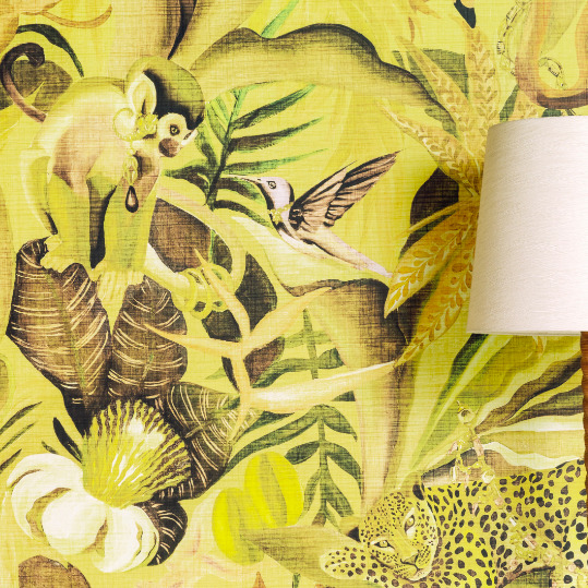 Gedetailleerd Elitis-behang uit de Matières Végétales Costalegre-collectie met een jungletafereel van een aap, vogel, luipaard en tropische planten op een gele achtergrond.