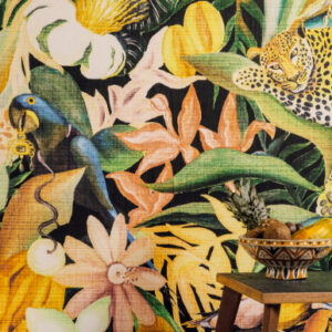 Decoratief Elitis-behang met een tropisch jungle-patroon van bloemen, een luipaard en een papegaai, met op de voorgrond een houten krukje met een schaal vol fruit.
