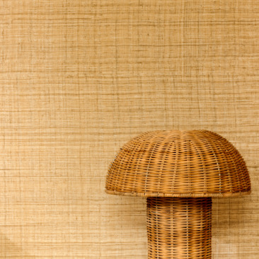 Rieten paddenstoelvormig object voor een wand met Elitis Matières Végétales behang in natuurlijke tinten.