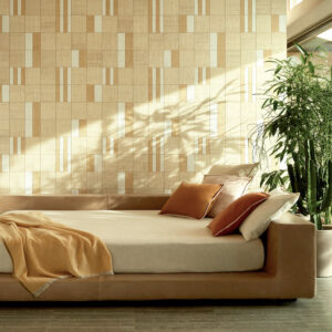 Modern interieur met Elitis behang Merida Wall Partitura RM 1020 02 achter een beige loungebank met warme kussens en omringd door groen.