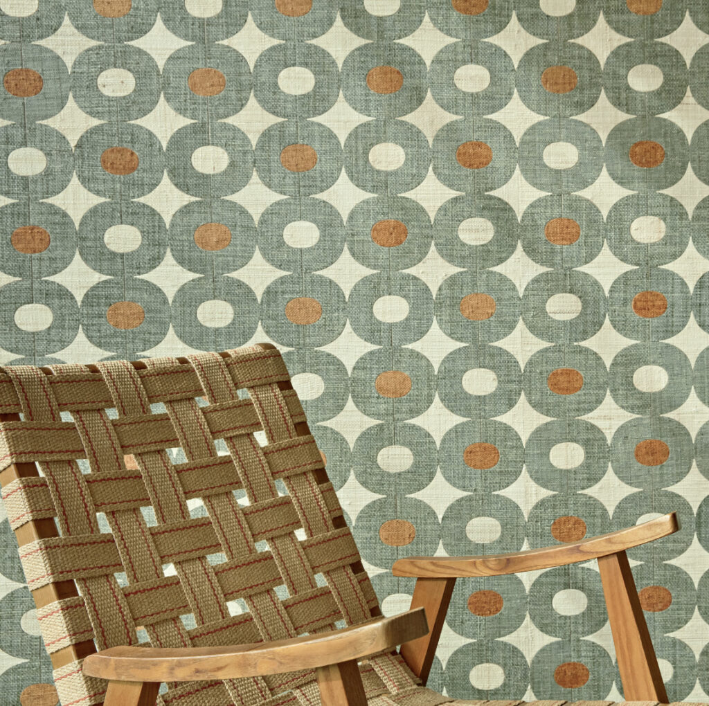 Groen Elitis Merida behang met retro geometrisch patroon en houten stoel met geweven zitting.
