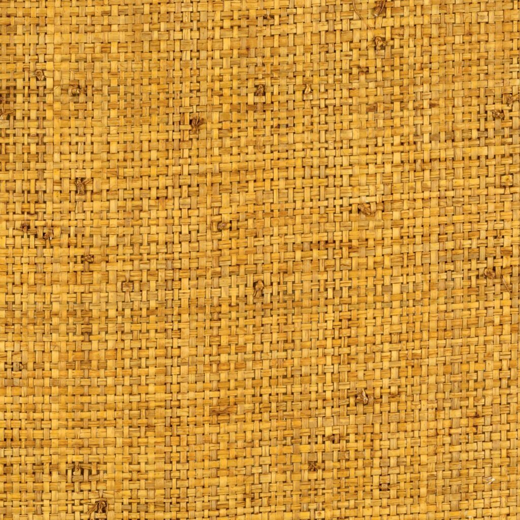 Natuurlijke wandbekleding van geweven Elitis Merida Cesteria behang in een warme, goudbruine tint.