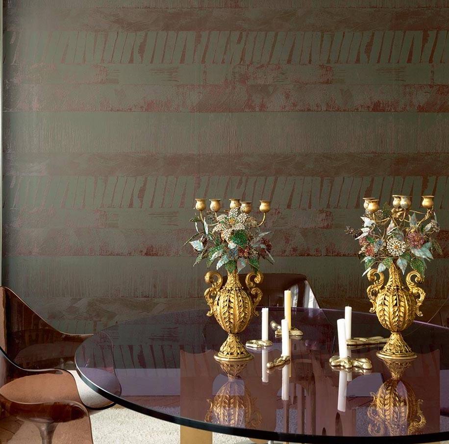 Luxe interieur met Elitis-behang Mouvements Impulsion RM 1022 65, gouden kandelaars en een ronde glazen tafel.