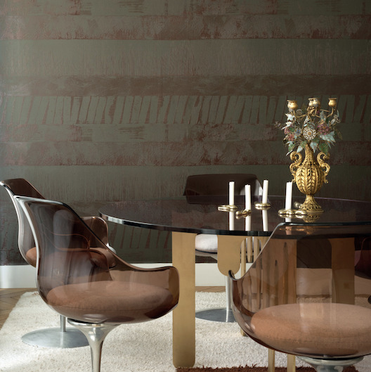 Moderne eetkamer met Elitis Mouvements Impulsion behang, een glazen tafel, designstoelen en een goudkleurige kandelaar.