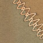Decoratief Elitis Sauvages Blasons behang met een zigzaggend patroon in warme aardetinten op een textuurachtige achtergrond.