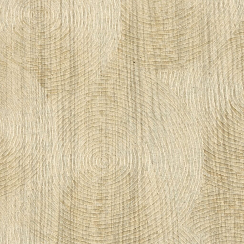 Beige wandbekleding Elitis Bois Sculpte Volute met reliëf en cirkelvormig houtnerfpatroon.