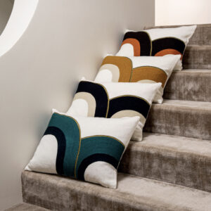 Vier Elitis Bridge CO 216 25 02 sierkussens met grafisch patroon liggen op een trap met beige tapijt.