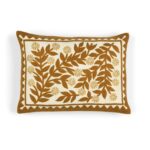 Decoratief Elitis Canopee kussen met bruine bladeren en bloemmotief op een crèmekleurige achtergrond.