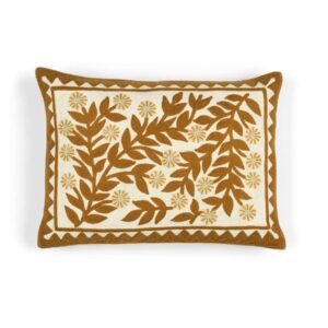 Decoratief Elitis Canopee kussen met bruine bladeren en bloemmotief op een crèmekleurige achtergrond.