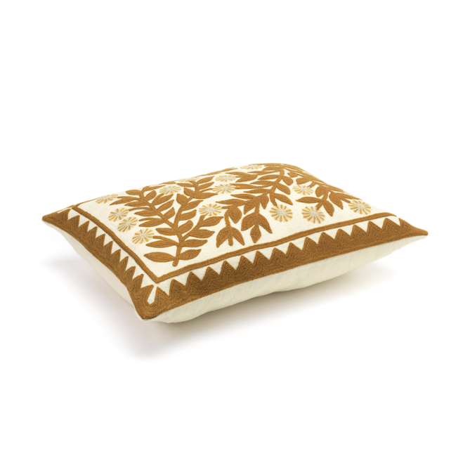 Zijaanzicht van het Elitis Canopée kussen CO 246 35 02 met bruin blad- en bloemenpatroon op een crèmekleurige ondergrond.