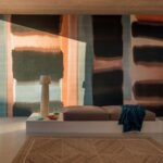 Modern interieur met een Elitis Ceres Abstrait VP 1015-02 wandbekleding in zachte aardetinten met een minimalistische ligbank en stijlvolle decoratie.