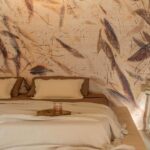 Sfeervolle slaapkamer met Elitis Ceres Ballet VP 1014-01 wandbekleding en neutraal beddengoed.