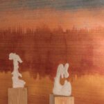 Twee abstracte, witte sculpturen op houten sokkels voor een Elitis Ceres Proserpine VP 1012-01 wandbekleding met warme oranje en roodbruine tinten.