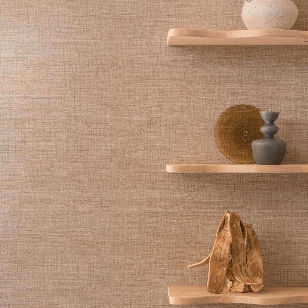 Decoratieve houten wandplanken met keramische en houten objecten tegen Elitis Ceres Rhea VP 1008 behang in een warme, natuurlijke tint.