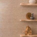Decoratieve houten wandplanken met keramische en houten objecten tegen Elitis Ceres Rhea VP 1008 behang in een warme, natuurlijke tint.