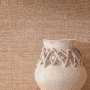 Rustieke keramische vaas met decoratief touwdetail tegen een beige Elitis Ceres Rhea VP 1008 wandbekleding.