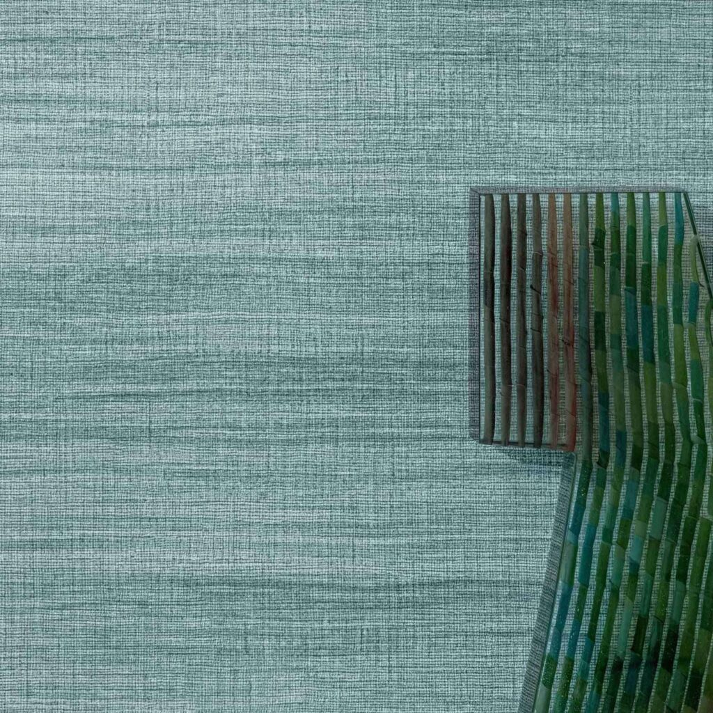 Groene Elitis Ceres Rhea VP 1008 wandbekleding met geplooide, kleurrijke textielaccenten aan de rechterzijde.
