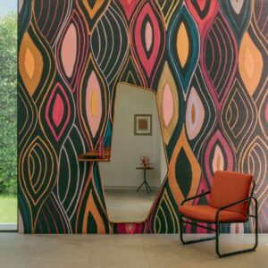Interieur met Elitis Cordes Sensibles Arabesque VP 1002-02 wandbekleding, een asymmetrische spiegel en een oranje fauteuil.
