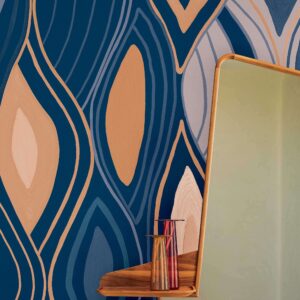 Detailopname van het Elitis Cordes Sensibles Arabesque VP 1002-03 behang met abstract patroon in blauw, beige en koper, naast een spiegel en glazen vazen op een houten plank.