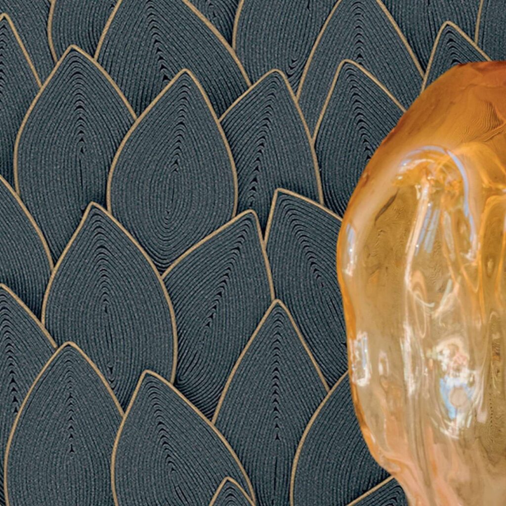 Detail van het Elitis Cordes Sensibles behang met bladpatroon in reliëf en een transparant amberkleurig object op de voorgrond.
