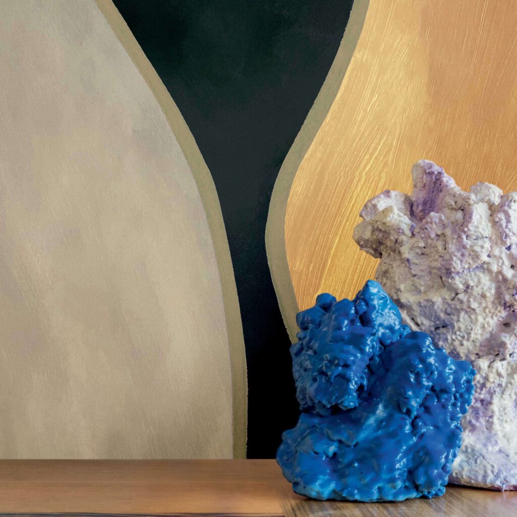 Detailopname van Elitis Cordes Sensibles wandbekleding met organische vormen, voor een houten oppervlak met blauwe en paarse sculpturen.