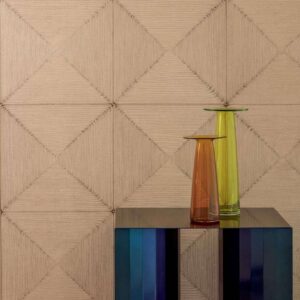 Decoratieve wand met Elitis Cordes Sensibles panelen in zandkleur, met op de voorgrond een moderne tafel en twee gekleurde glazen vazen.