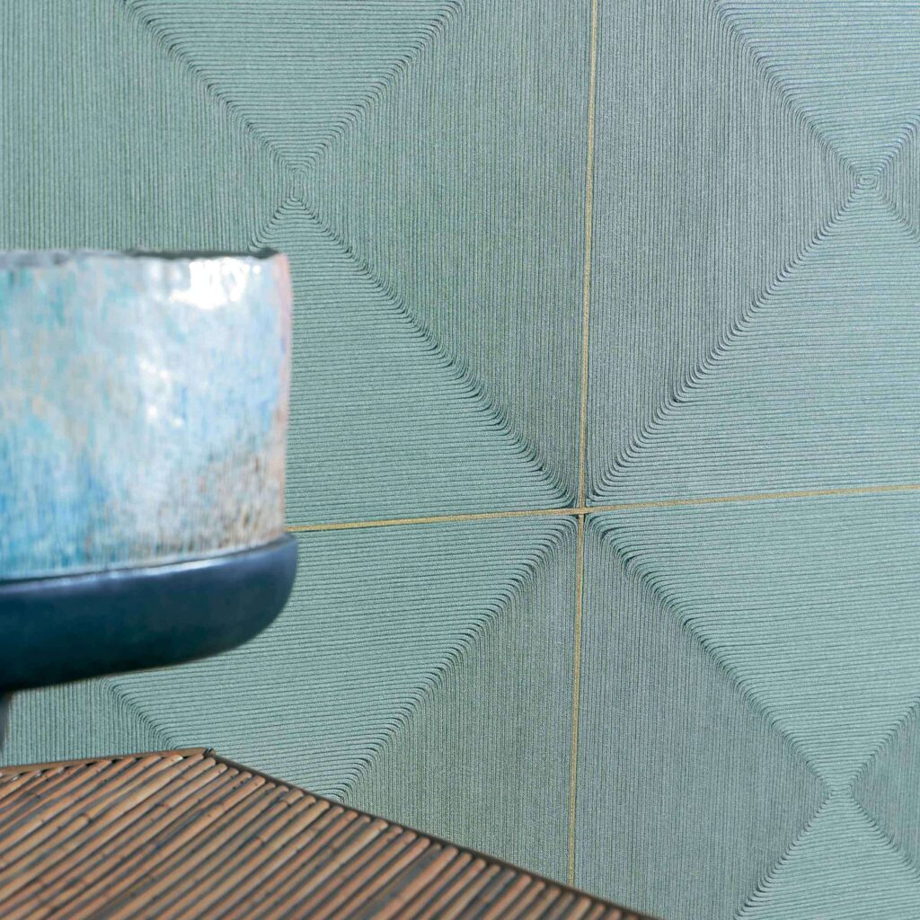 Detail van Elitis Cordes Sensibles wandbekleding met geometrisch koordpatroon in groenblauw, naast een keramische schaal.