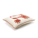Crèmekleurig Elitis Cristobal kussen met rood geborduurde botanische en dierlijke motieven.