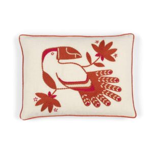 Decoratief Elitis Cristobal kussen met rood-oranje geborduurde toekan en bladdessin op een crèmekleurige achtergrond.